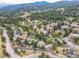 Aerial view of the property showcasing a picturesque neighborhood with lush greenery, a pond, and mountain views at 23846 Genesee Village Rd, Golden, CO 80401
