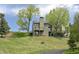 Backyard view of the property, featuring multi-level decks and grassy hillside at 23846 Genesee Village Rd, Golden, CO 80401