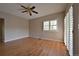 Neutral bedroom with hardwood floors, ceiling fan, bright window and sliding door at 23846 Genesee Village Rd, Golden, CO 80401