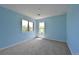 A light blue bedroom with neutral carpet and two windows providing natural light at 23846 Genesee Village Rd, Golden, CO 80401