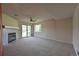Bright living room with a fireplace, ceiling fan, neutral carpet, and sliding glass doors to the outside at 23846 Genesee Village Rd, Golden, CO 80401