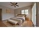 Comfortable main bedroom featuring a bed, bench, and a sliding door to the outdoor balcony at 23846 Genesee Village Rd, Golden, CO 80401