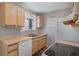 Functional kitchen with wood cabinets, white appliances, and a window for natural light at 16980 E Stanford Ave, Aurora, CO 80015