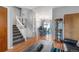 Open-concept living room flowing into the dining area with hardwood floors and staircase at 16980 E Stanford Ave, Aurora, CO 80015