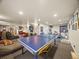 Open basement layout with ping pong table, tv, and workout equipment at 6432 S Robb Ct, Littleton, CO 80127