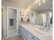 Well-lit bathroom featuring double sinks, framed mirrors, and tile flooring at 6432 S Robb Ct, Littleton, CO 80127