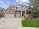 Charming two-story brick home with a three car garage and lush front yard at 6432 S Robb Ct, Littleton, CO 80127