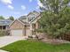 Charming two-story brick home with a well-manicured lawn and three-car garage at 6432 S Robb Ct, Littleton, CO 80127