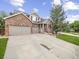 Charming two-story brick home with a three-car garage and beautifully landscaped front yard at 6432 S Robb Ct, Littleton, CO 80127