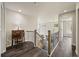 Upper hallway landing featuring dark laminate floors, an antique desk, and decorative railing at 6432 S Robb Ct, Littleton, CO 80127