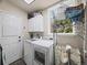 A tidy laundry room with modern washer and dryer, storage, and natural light at 6432 S Robb Ct, Littleton, CO 80127