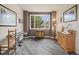 Inviting sitting room with hardwood floors and a large window with backyard views at 6432 S Robb Ct, Littleton, CO 80127