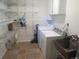 Functional laundry room featuring shelving, cabinets, washer, dryer, and sink, for efficient chore management at 1271 Xapary St, Aurora, CO 80011