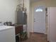 Utility room featuring a water heater, sink, and laundry machine, ensuring essential services and functionality at 1271 Xapary St, Aurora, CO 80011