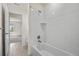 Tiled bathroom featuring a shower-tub combo and neutral walls at 14912 Vienna Cir, Parker, CO 80134