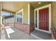 View of the front porch of a charming home, featuring a brick base, a painted door, and a covered entrance at 14912 Vienna Cir, Parker, CO 80134