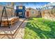 Backyard with patio set on wooden deck and shed structures, surrounded by lush grass at 3109 N Williams St, Denver, CO 80205