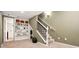 Basement area with neutral carpet, built-in shelving, and staircase with white railings at 3109 N Williams St, Denver, CO 80205