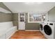 Bright laundry room includes a bench, storage and modern appliances at 3109 N Williams St, Denver, CO 80205