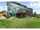 Lush green backyard featuring a wooden deck on a two-story home, ideal for relaxation and outdoor enjoyment at 3543 Foxridge Trl, Highlands Ranch, CO 80126
