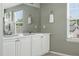 Double vanity bathroom with white cabinets, large mirrors, and modern fixtures at 3543 Foxridge Trl, Highlands Ranch, CO 80126