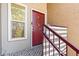 This apartment entrance features a red door, staircase with handrail, and adjacent window at 5300 E Cherry Creek South Dr # 124, Denver, CO 80246
