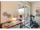 Bright office area with desk, exercise bike, and sliding glass doors to the outside at 5300 E Cherry Creek South Dr # 124, Denver, CO 80246