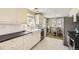 Bright kitchen featuring white cabinets, modern countertops, and a farmhouse sink with wood style floors at 1374 S Beach Ct, Denver, CO 80219