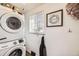 Bright laundry area features a stacked washer and dryer and wall decor at 1374 S Beach Ct, Denver, CO 80219
