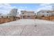 Large backyard covered in snow with a wooden fence, and partial view of the house and other surrounding homes at 24285 E Wagontrail Ave, Aurora, CO 80016