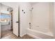 Bright bathroom featuring a bathtub and shower, with tile surround, and easy access to the bedroom at 5756 N Genoa Way # 12-305, Aurora, CO 80019