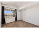 Sunlit bedroom with plush carpet and a large window offering views of the community at 5756 N Genoa Way # 12-305, Aurora, CO 80019