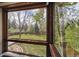 A backyard view through a window, showcasing a large grassy lawn and mature trees at 6247 S Locust St, Centennial, CO 80111