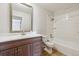 Bathroom with wood vanity, white sink, large mirror, and a shower/tub combo with tile surround at 6247 S Locust St, Centennial, CO 80111