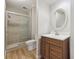 Bathroom with a glass-enclosed shower and modern wood vanity with a decorative mirror at 6247 S Locust St, Centennial, CO 80111