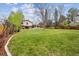 Expansive front yard with lush lawn, mature trees, and a charming two-story home with brick accents at 6247 S Locust St, Centennial, CO 80111