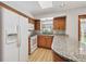 Close-up of kitchen featuring wood cabinets, granite counters, stainless fridge and appliances, and bright natural light at 6247 S Locust St, Centennial, CO 80111