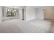 Spacious living room featuring a pendant light fixture, a large window with white shutters, and neutral carpeting at 6247 S Locust St, Centennial, CO 80111