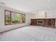Spacious living room with a brick fireplace, built-in shelving, a large window, and neutral carpeting at 6247 S Locust St, Centennial, CO 80111