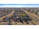 Wide aerial view of neighborhood homes with solar panels, manicured lawns, and proximity to highways at 4787 Dunkirk St, Denver, CO 80249