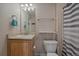 Standard bathroom featuring a single sink vanity, toilet, mirror, and a shower with a striped curtain at 4787 Dunkirk St, Denver, CO 80249