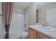 This bathroom features a shower with a neutral color and a wood cabinet at 4787 Dunkirk St, Denver, CO 80249