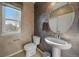 Stylish half-bathroom boasts a pedestal sink, decorative mirror, and neutral decor at 4787 Dunkirk St, Denver, CO 80249