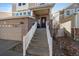 The brick front entrance has a stairway, with a glass detailed door, and small rock landscaping at 4787 Dunkirk St, Denver, CO 80249