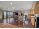 Open living room with an eat-in kitchen, island, hardwood floors, and big windows at 4787 Dunkirk St, Denver, CO 80249