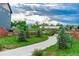 A serene backyard scene with lush greenery, a gravel pathway, and distant mountain views at 638 W 175Th Ave, Broomfield, CO 80023