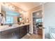 Bright bathroom featuring double vanity, modern fixtures, and a view into the bedroom at 638 W 175Th Ave, Broomfield, CO 80023