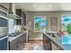 Well-lit kitchen with stainless steel appliances, gray countertops, and a view of the outdoors from the windows at 638 W 175Th Ave, Broomfield, CO 80023