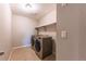 Modern laundry room with tile floor, two tone walls, modern washer and dryer, and shelving at 638 W 175Th Ave, Broomfield, CO 80023