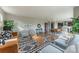 Open-concept living room showcasing stylish furniture, a modern rug, and seamless flow to the dining and kitchen areas at 638 W 175Th Ave, Broomfield, CO 80023